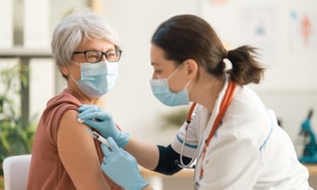 Doctor vaccinating a senior woman.