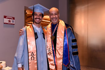 Young man with older man at graduation. 