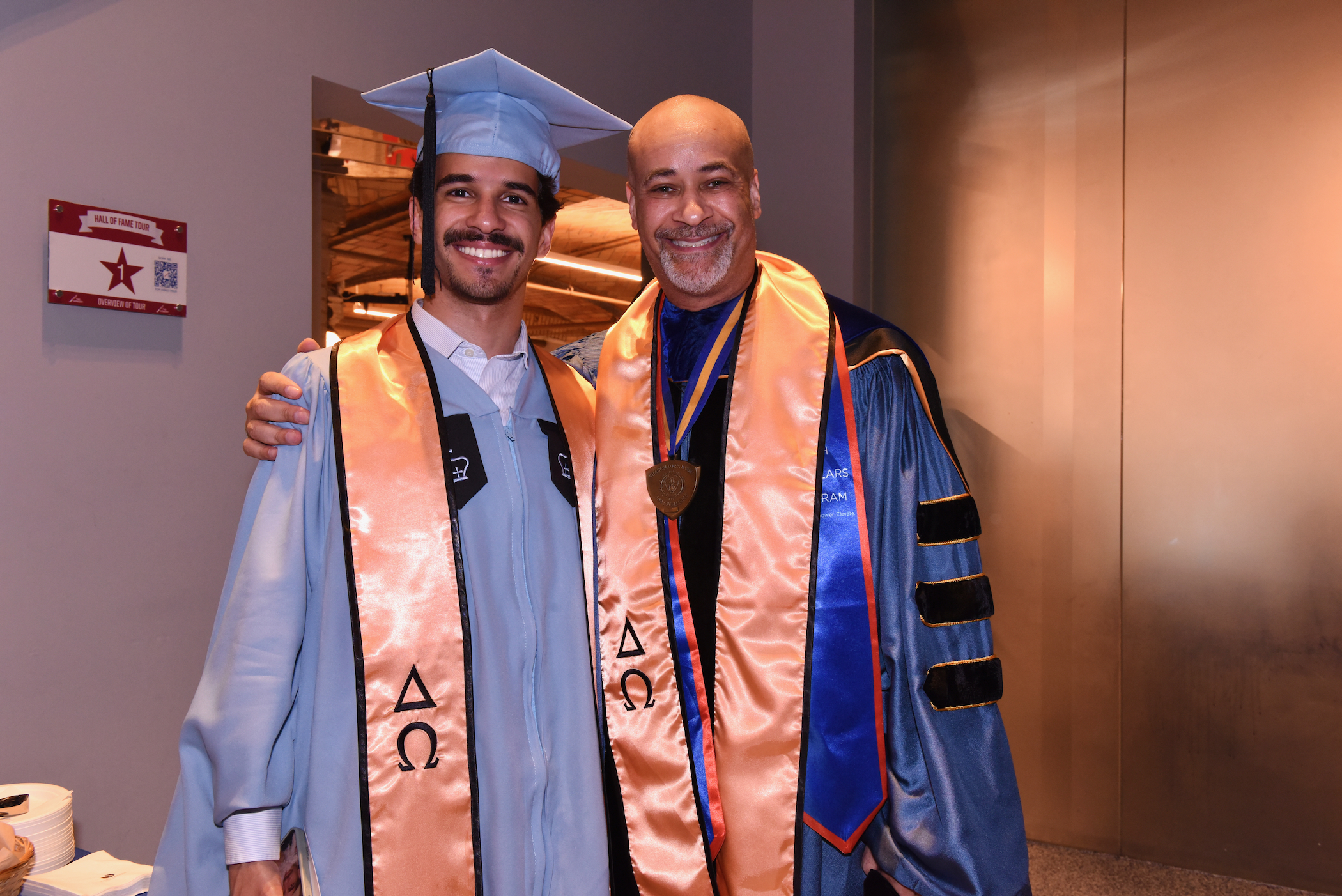 Young man with older man at graduation. 
